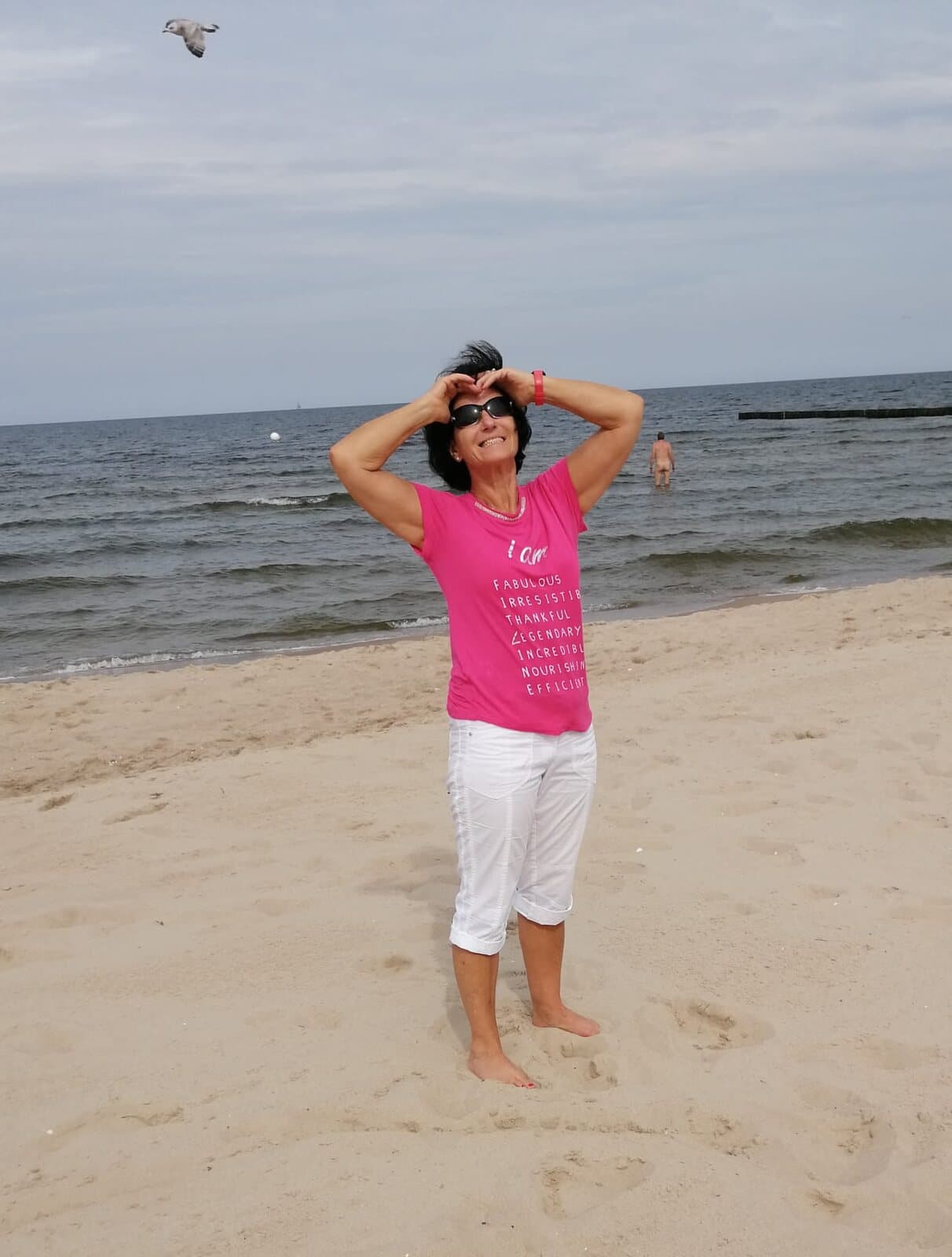 Anne Vierling am Meeresstrand, den Blick hinauf zur Sonne gerichtet